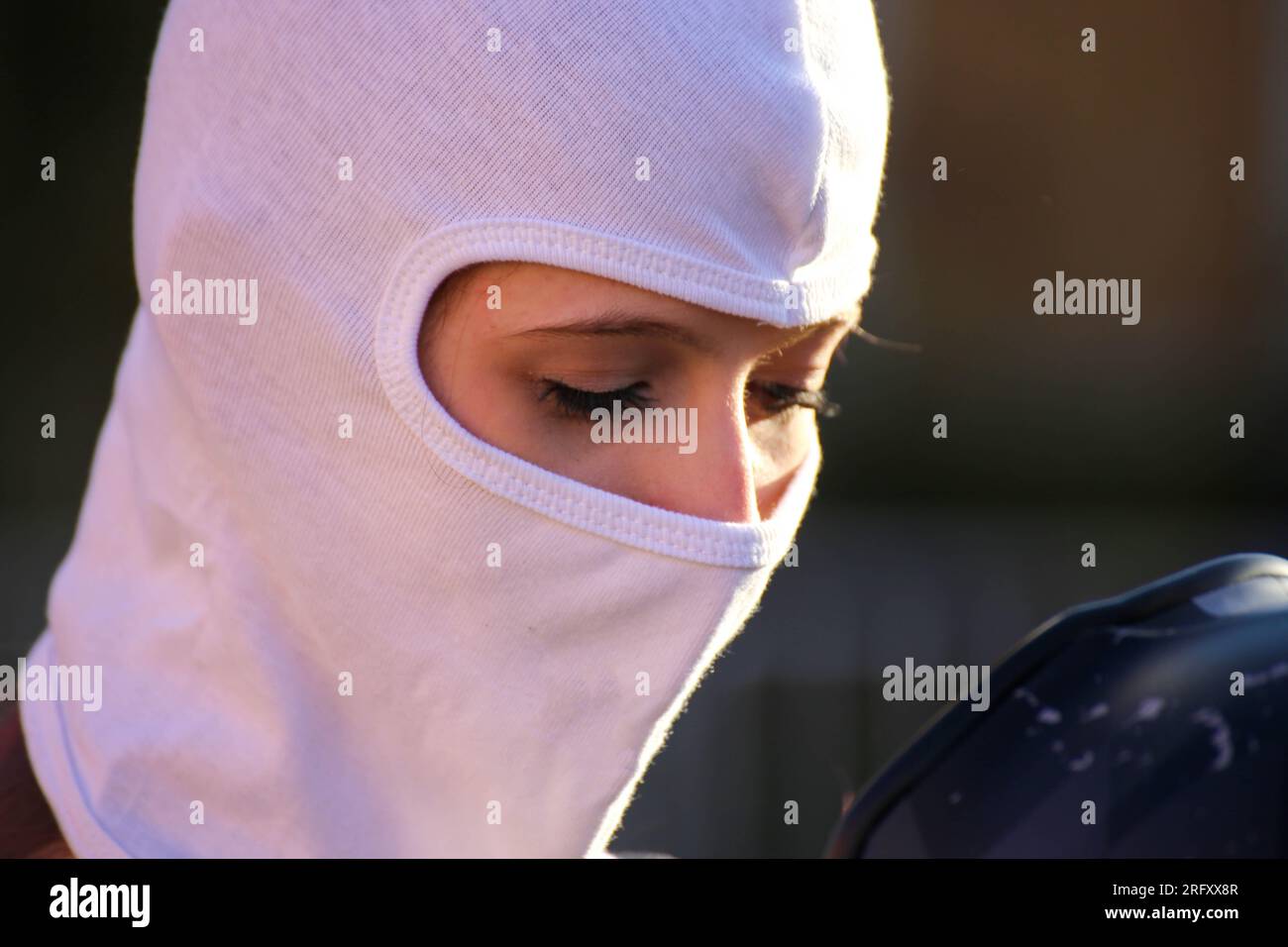 Female race car driver putting on her balaclava (Model released Stock