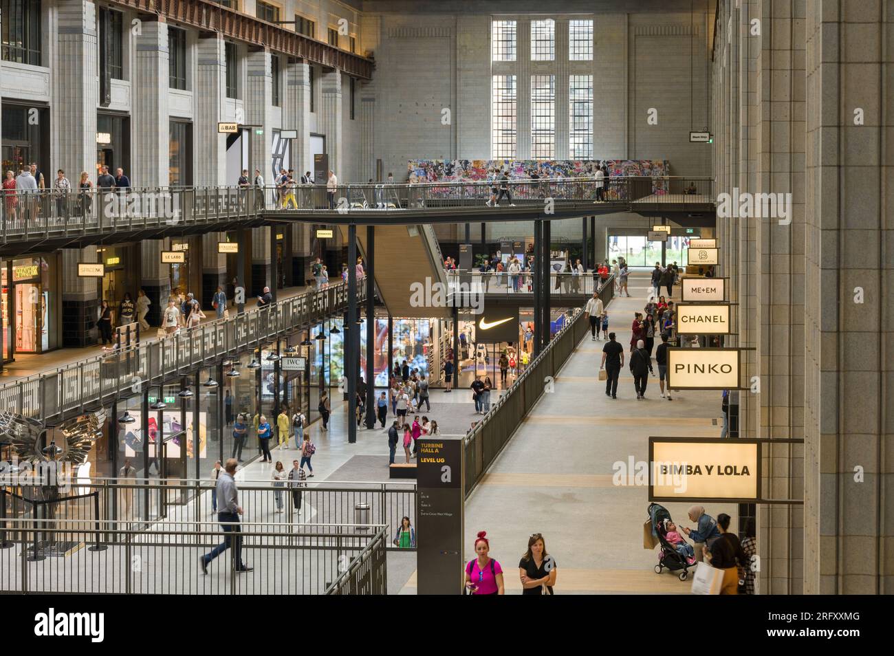 Interior of Battersea Power Station showing people walking past retail units as part of the redevelopment, London, UK Stock Photo