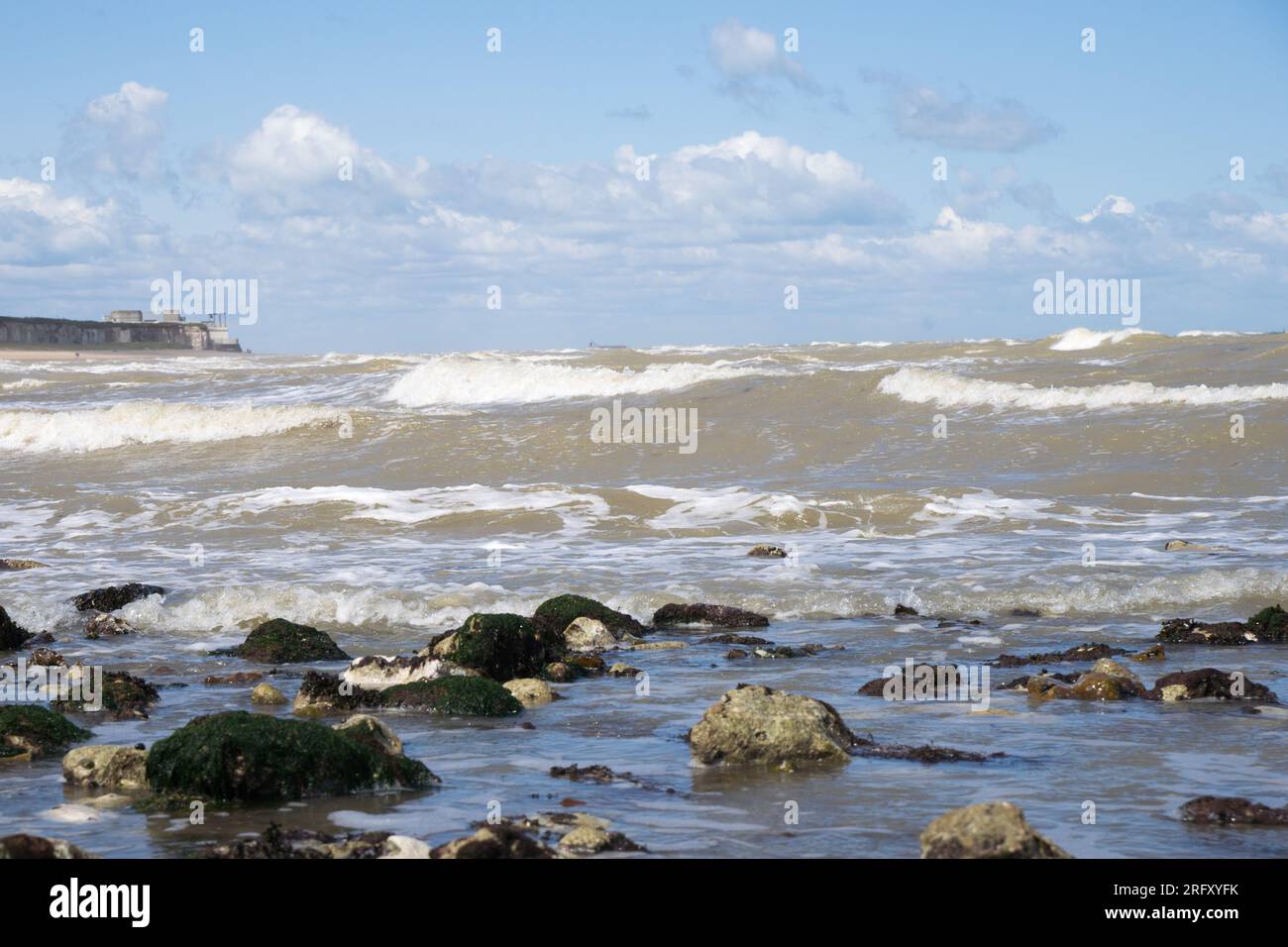 Kent UK. 06th August 2023. UK Weather. Strong  winds can be felt and choppy sea water seen at Kent south coast while Storm Antoni hits England' south west coast with near-80mph gusts. People still enjoying sunny day on beach swimming in incoming waves. Credit: xiu bao/Alamy Live News Stock Photo