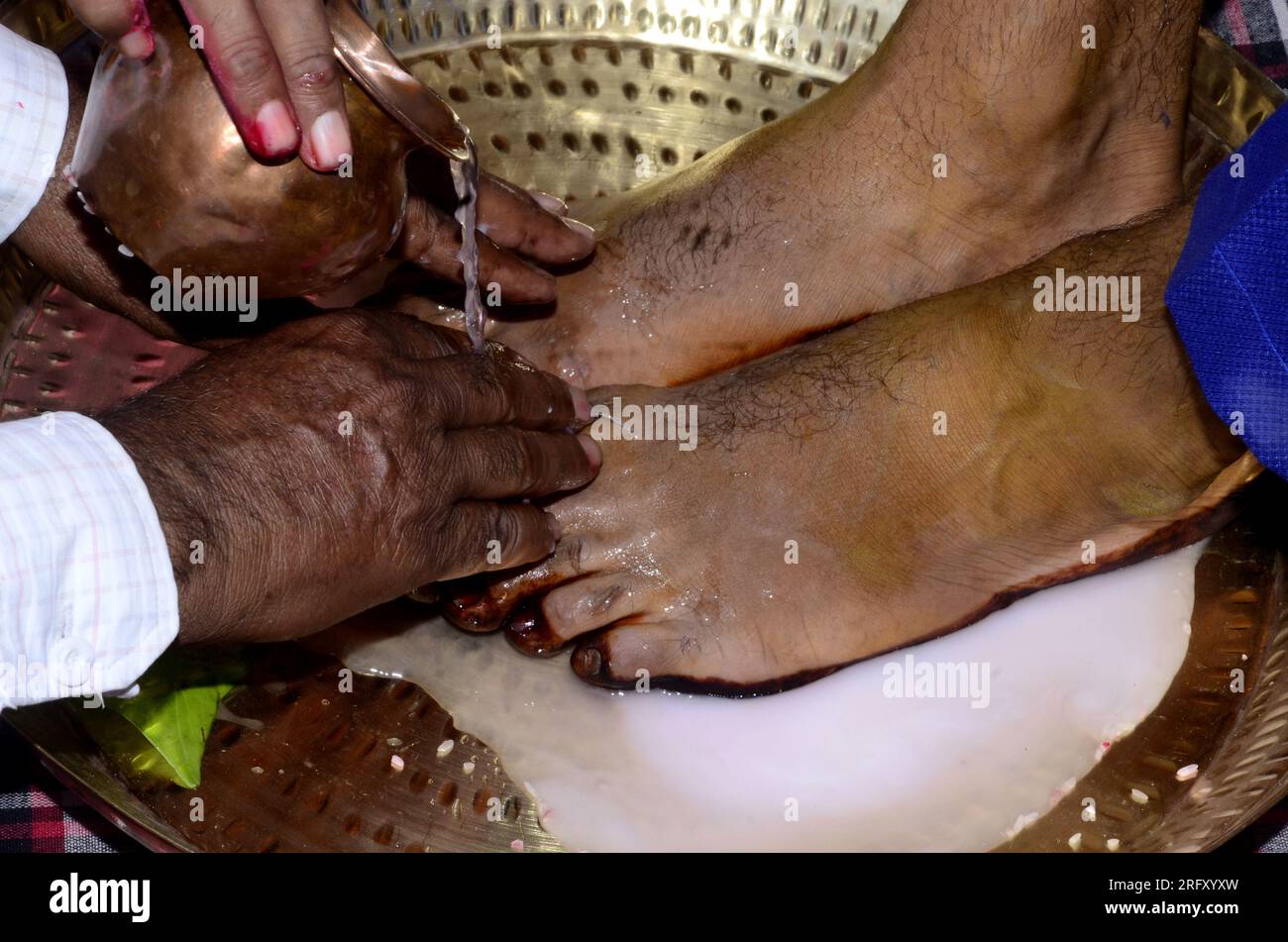 Photograph of a Hindu groom washing feet during a traditional wedding ceremony Stock Photo