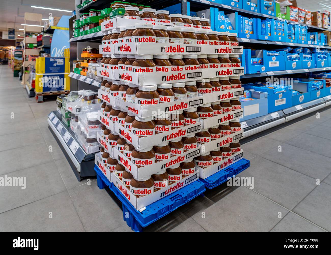 Italy - August 05, 2023: Ferrero Nutella in stacked glass jars for sale on pallets displayed in Italian discount supermarket store Stock Photo