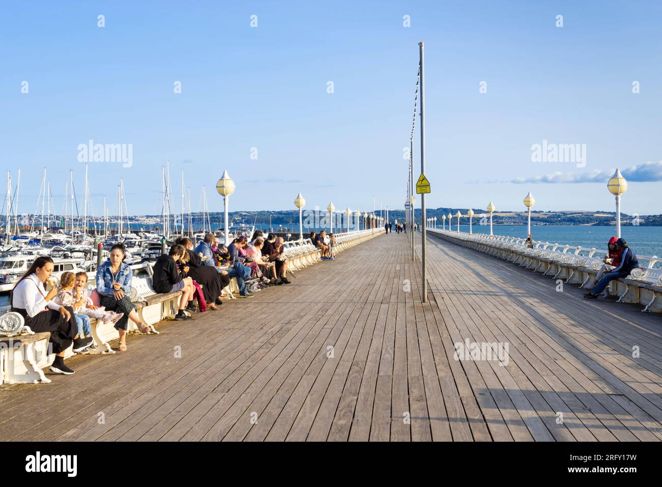Torquay Devon Torbay Tourists eating fish and chips on Princess Pier