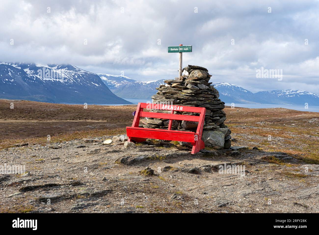 Summit of Barheia with a red bench and a cairn. Scenic vew of the surrounding mountains and the fjord. Svensby, Lyngen Alps, Lyngen, Northern Norway Stock Photo