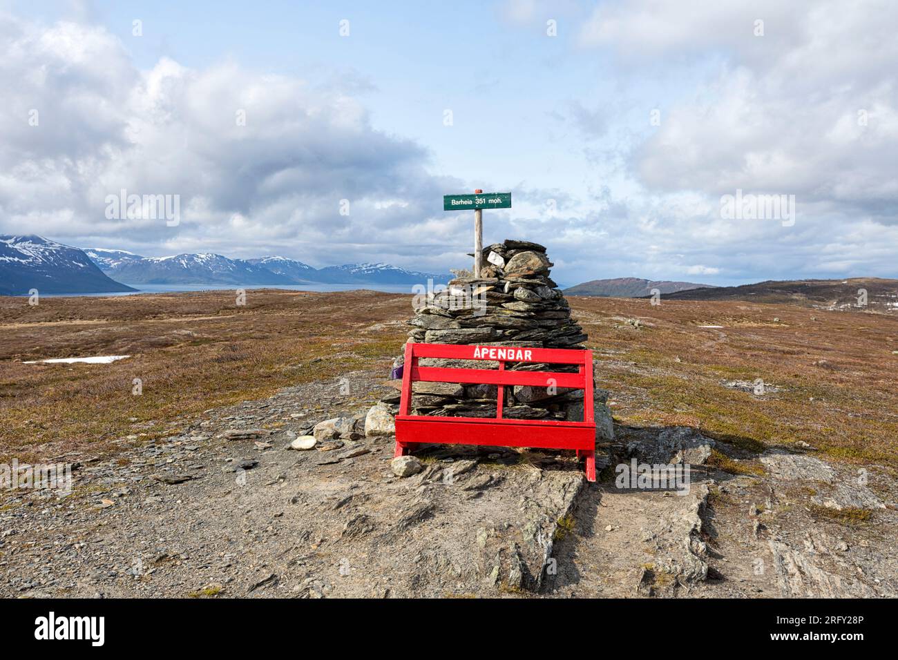 Summit of Barheia with a red bench and a cairn. Scenic view of the surrounding mountains and the fjord. Svensby, Lyngen Alps, Lyngen, Northern Norway Stock Photo