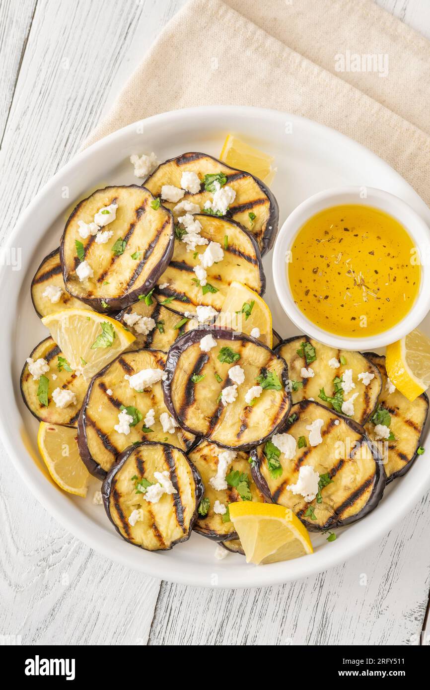 Grilled eggplant slices with garlic vinaigrette and feta Stock Photo