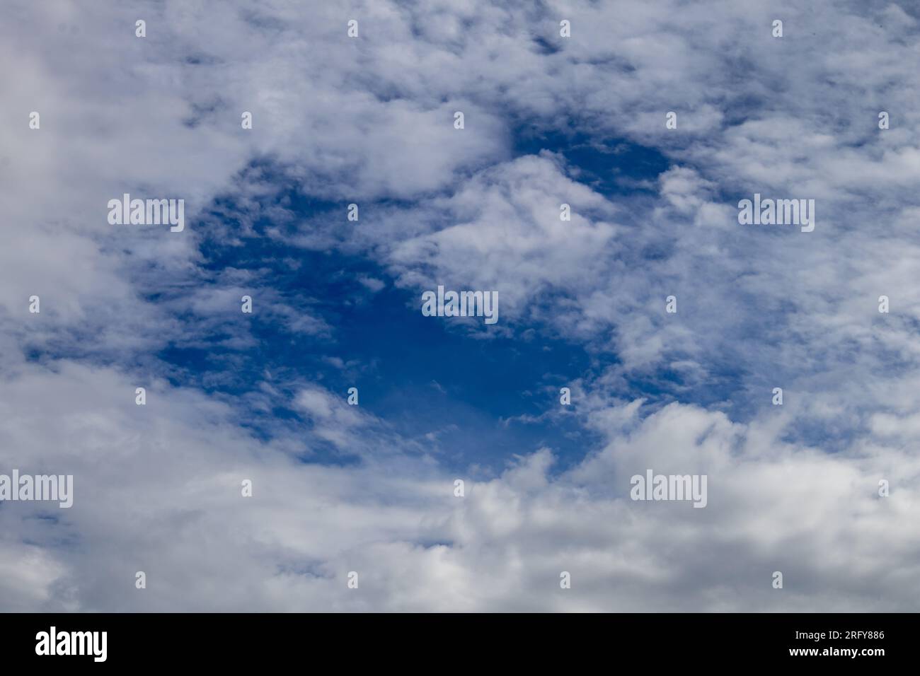Blue clearing between white clouds Stock Photo