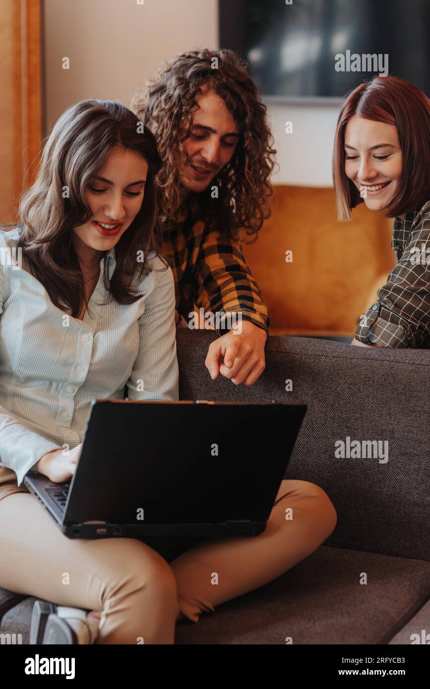 Young, intelligent software developers working as team at the office sitting on a grey sofa Stock Photo