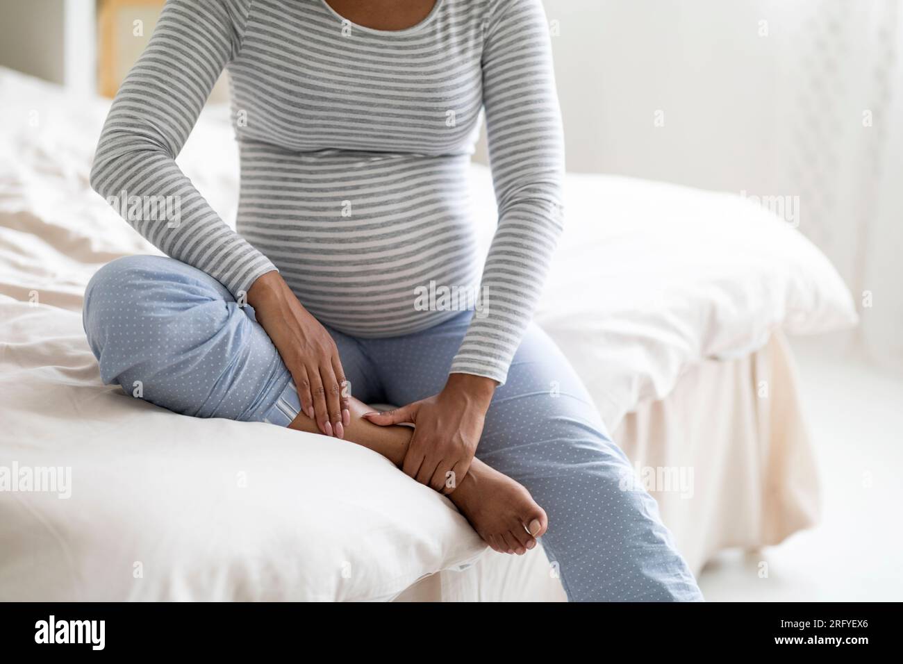 Pregnancy and health problems. Black pregnant woman massaging her