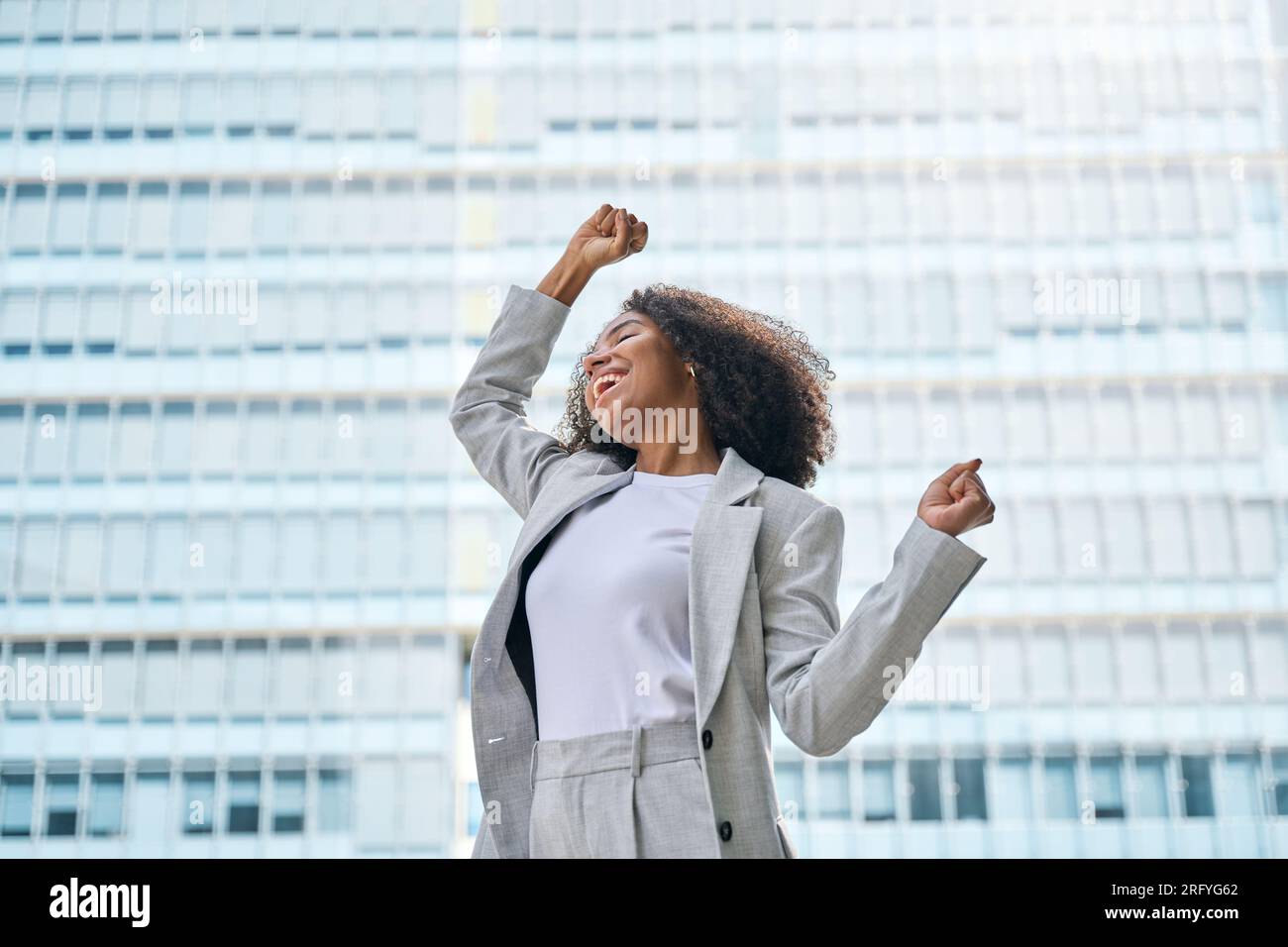 Happy excited young African American business woman celebrating success ...