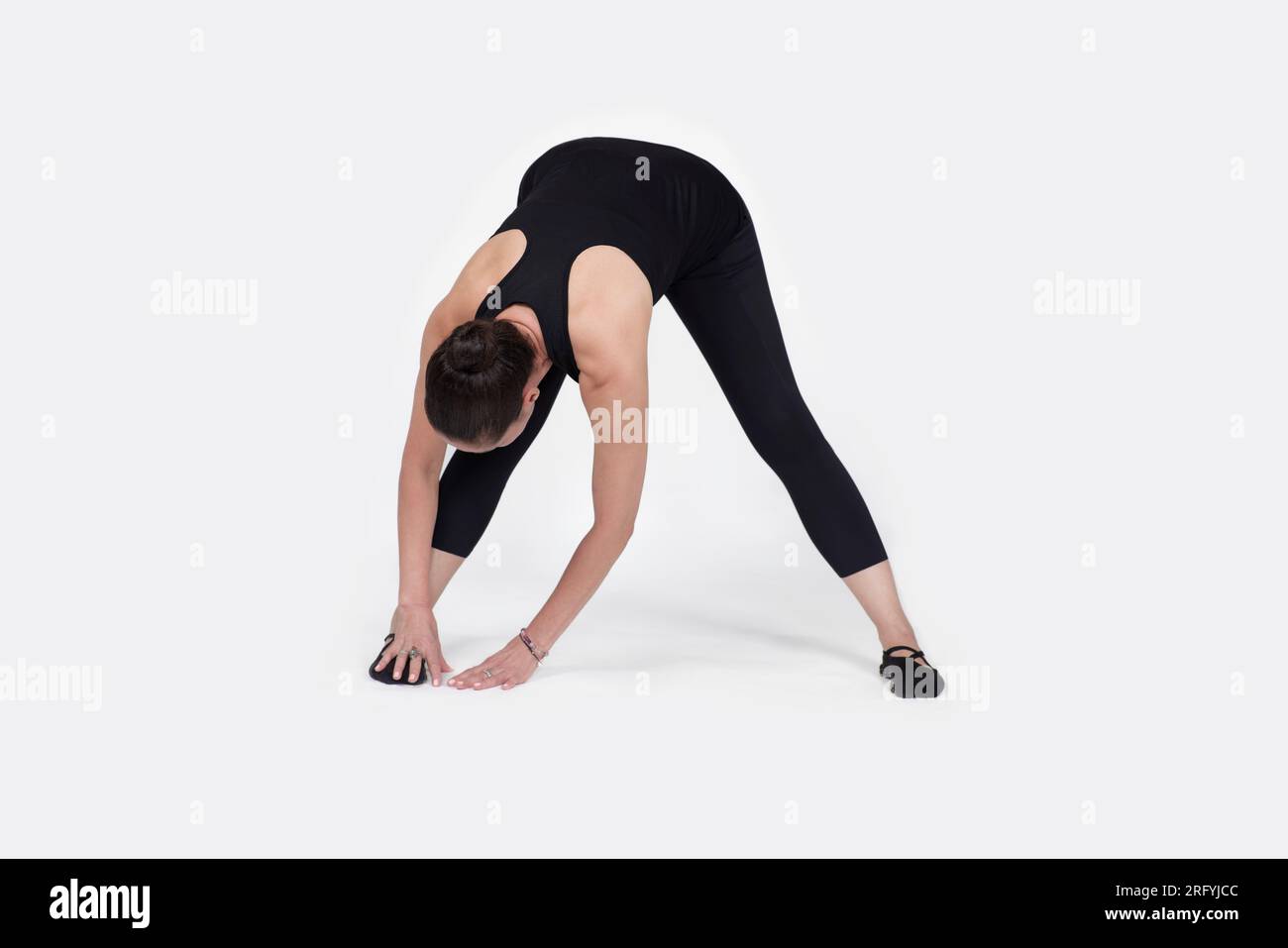 Specialized trauma releasing exercises for elderly people, 55 years old woman trainer posing for exercises. Hamstring pose, in the studio isolated on Stock Photo