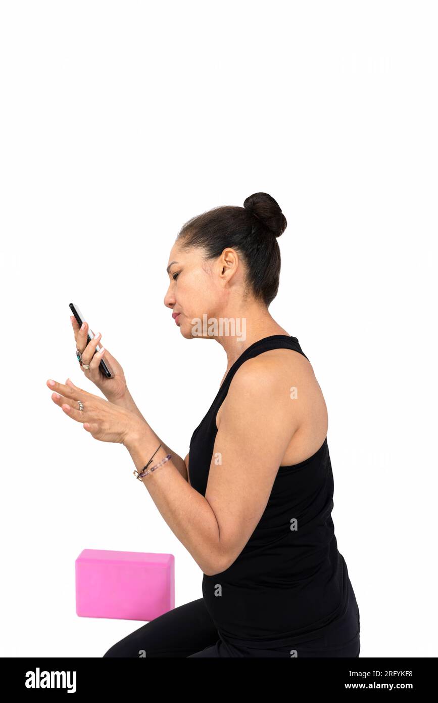 Trauma releasing exercises, senior citizen woman in her sixties , reading on the phone exercises for trauma recovery Stock Photo