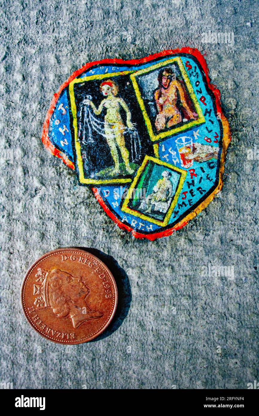 London, UK. Tiny work of art painted on a discarded piece of chewing gum by Ben Wilson 'Chewing Gum Man' on the pavement Stock Photo