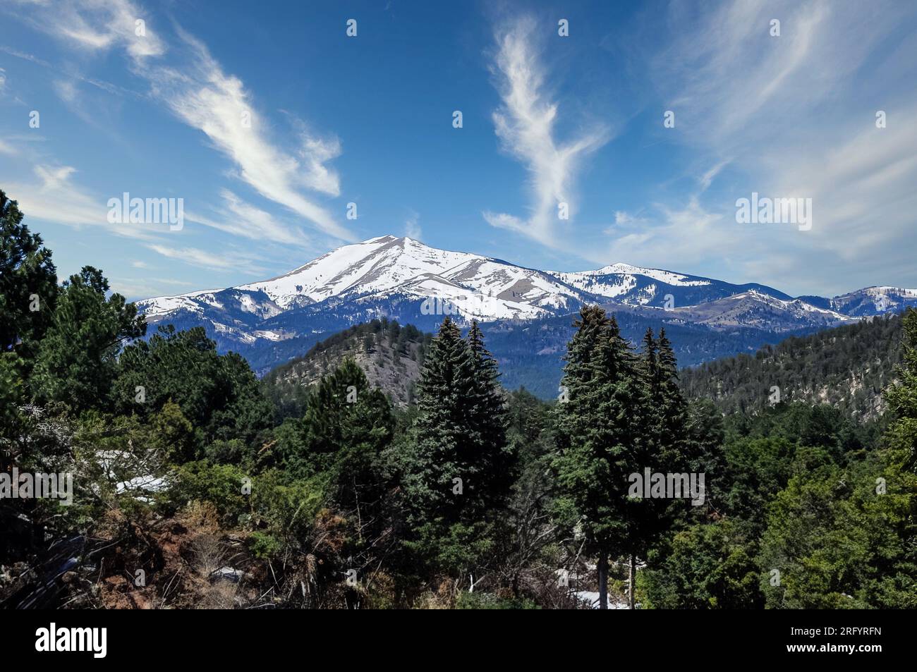 A panoramic view captures the snowcapped peak of Sierra Blanca, as