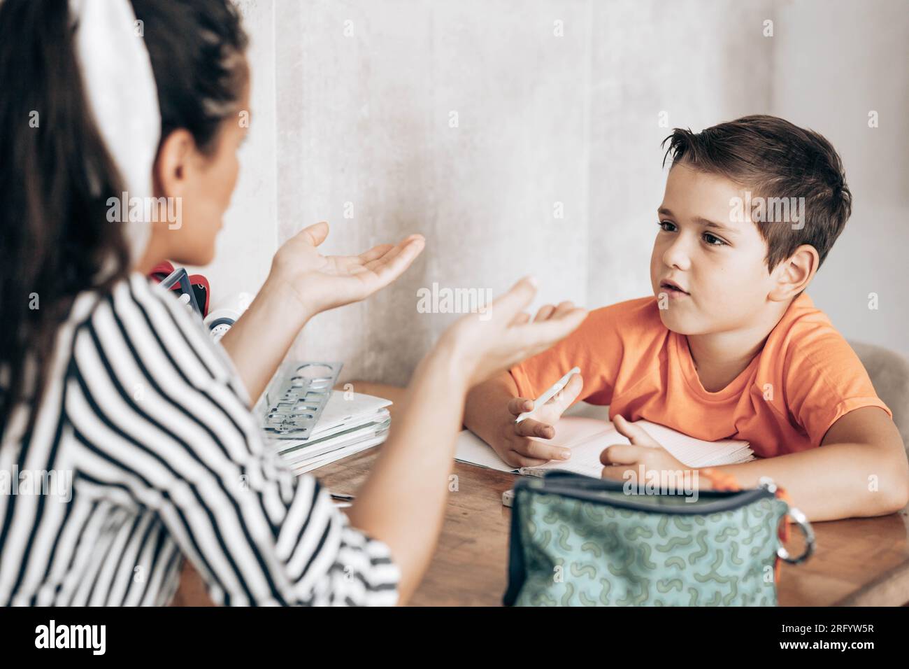 Little school boy doing homework with his mom helping him Stock Photo