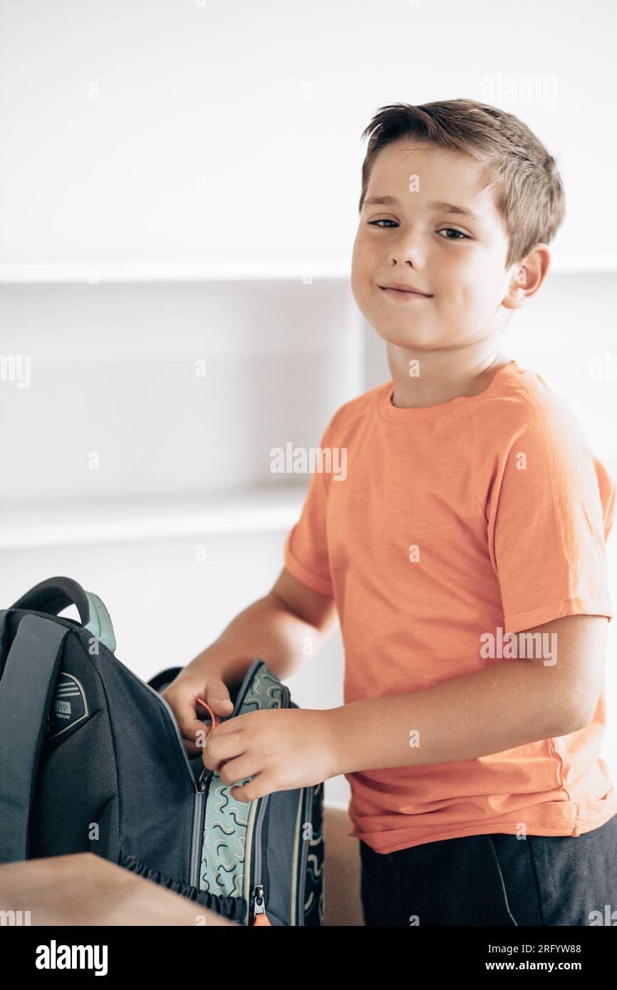 Little school boy preparing schoolbag for school Stock Photo