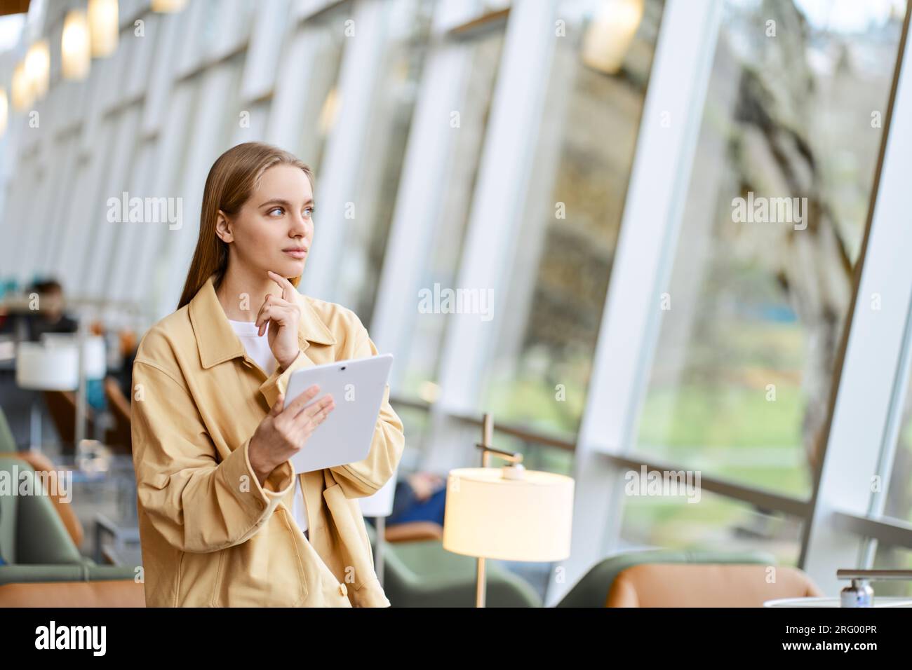 Thoughtful girl student using digital tablet looking away. Copy space Stock Photo