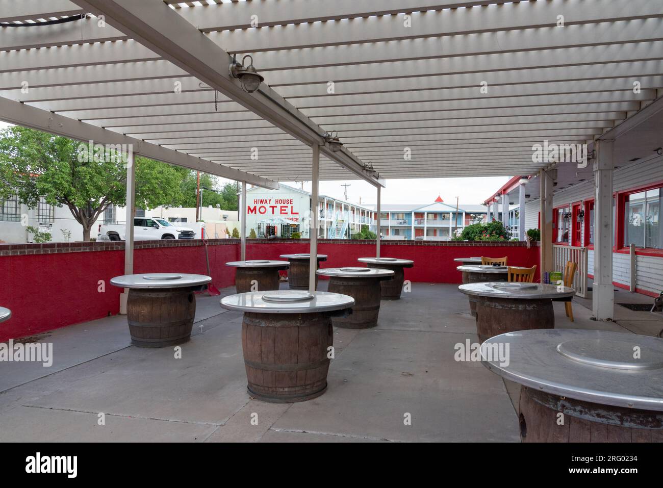 Outdoor covered patio, tables made from wooden barrels and facade of