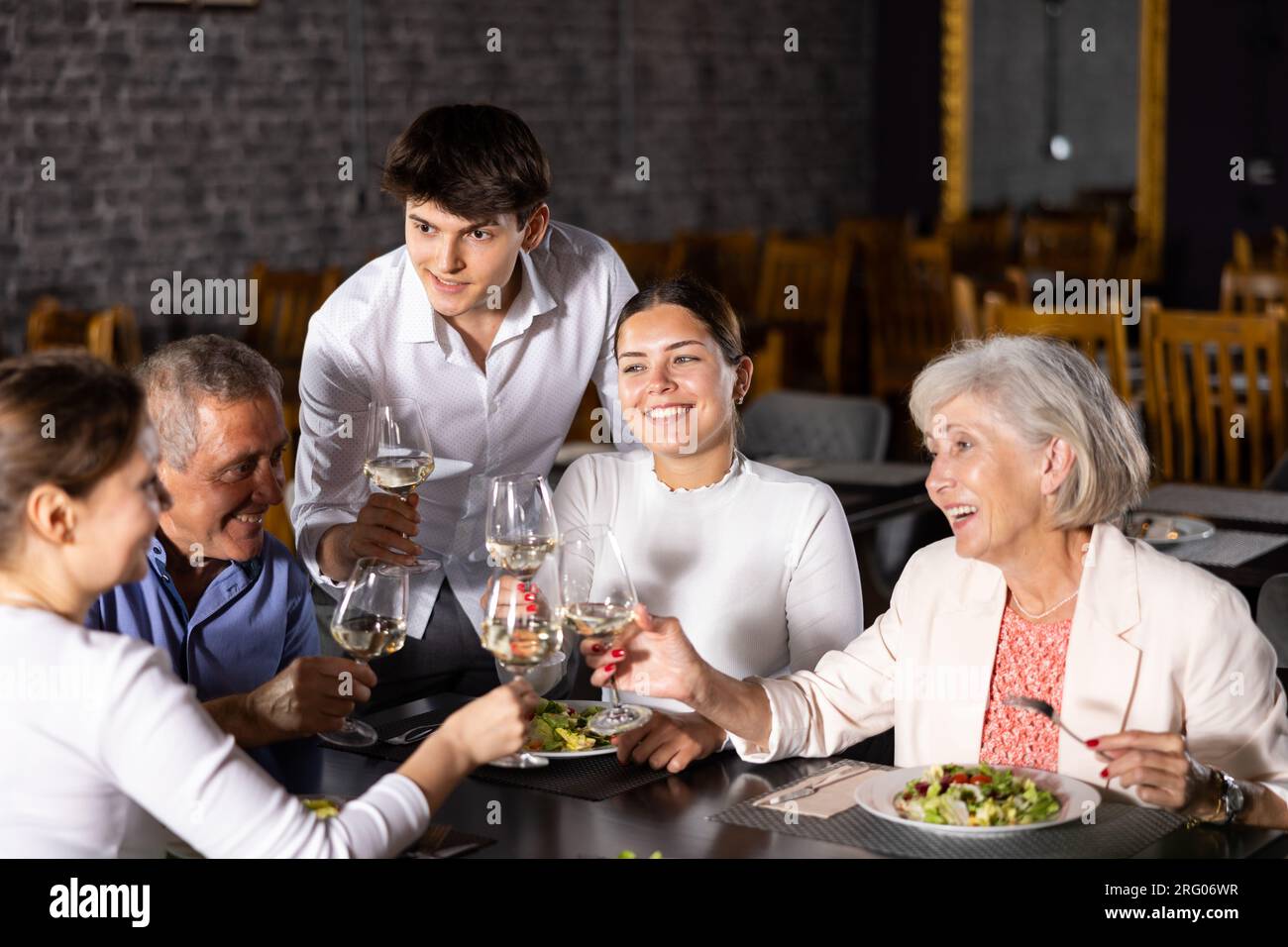 Large family, company of spouses in restaurant, eat, celebrate important event, communicate. Stock Photo