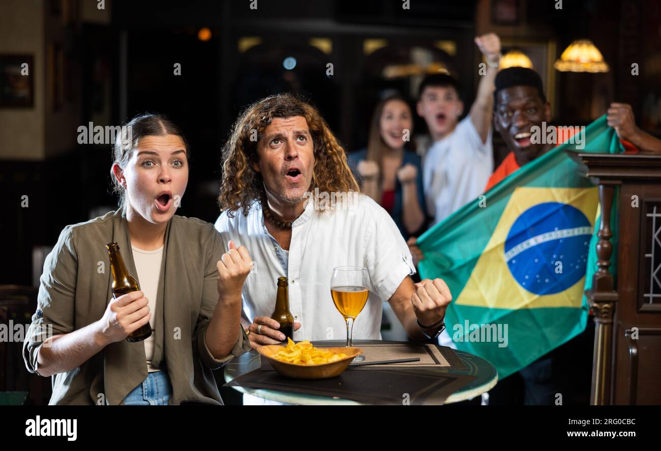Excited couple rooting for favorite brazilian team in sports bar Stock ...