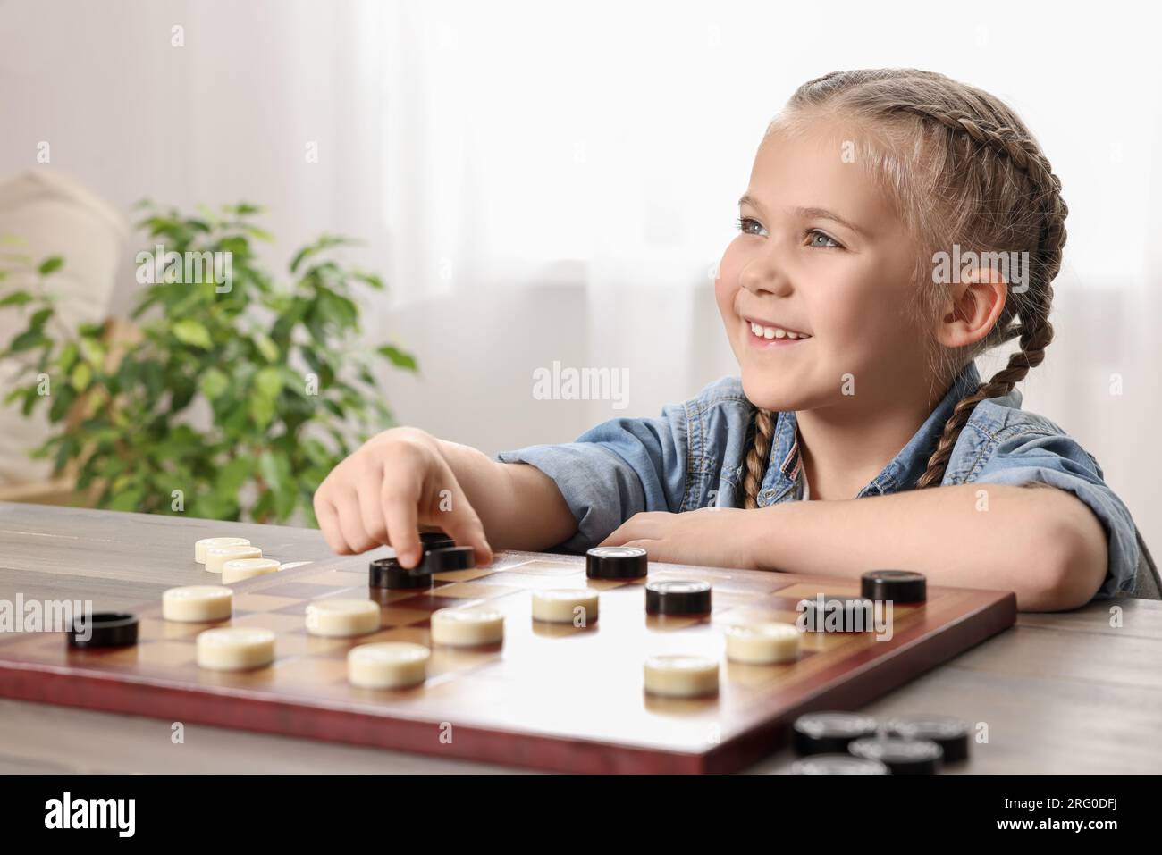 Woman playing chess thinking of next move Stock Photo - Alamy