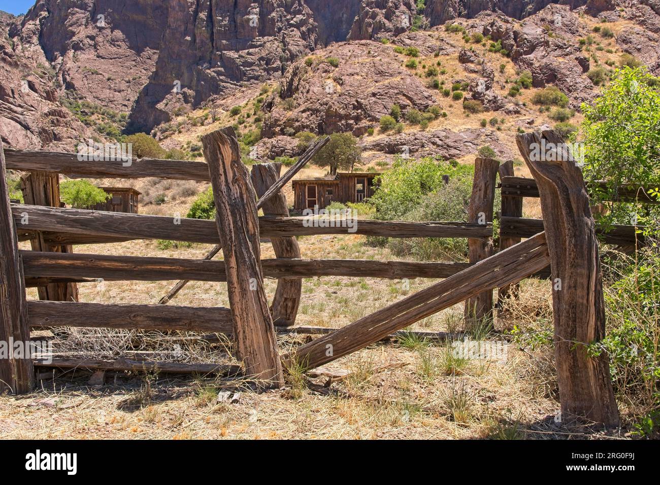 Rustic wood fencing frame weathered shack of abandoned mining camp on golden slopes of Organ mountains Stock Photo