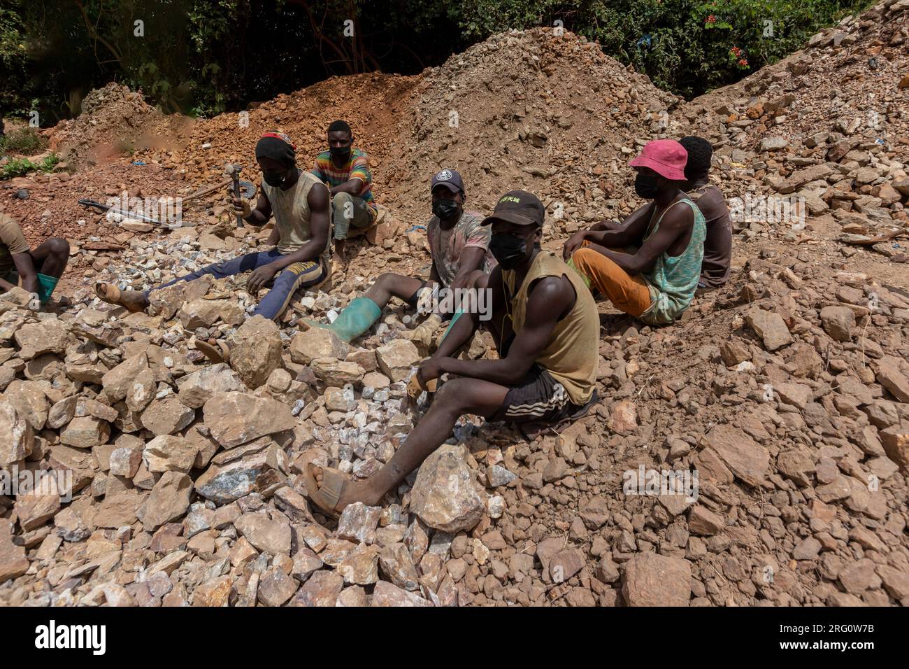 Artesanal miners crushing gold ore with hammers, in the gold extraction process Stock Photo