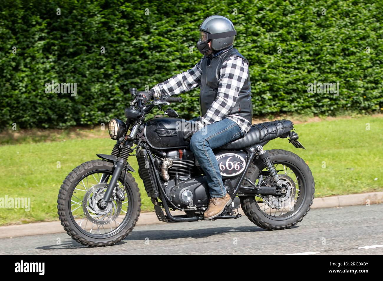 Whittlebury,Northants.,UK - Aug 6th 2023. 2017 black Triumph Street Scrambler motorcycle travelling through an English village. Stock Photo