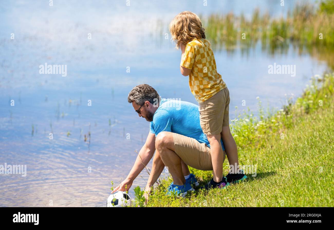 Father trainer and child son teaming up outdoor. Father dad and son enjoying outdoor activities together. Outdoor adventures between father and son. A Stock Photo