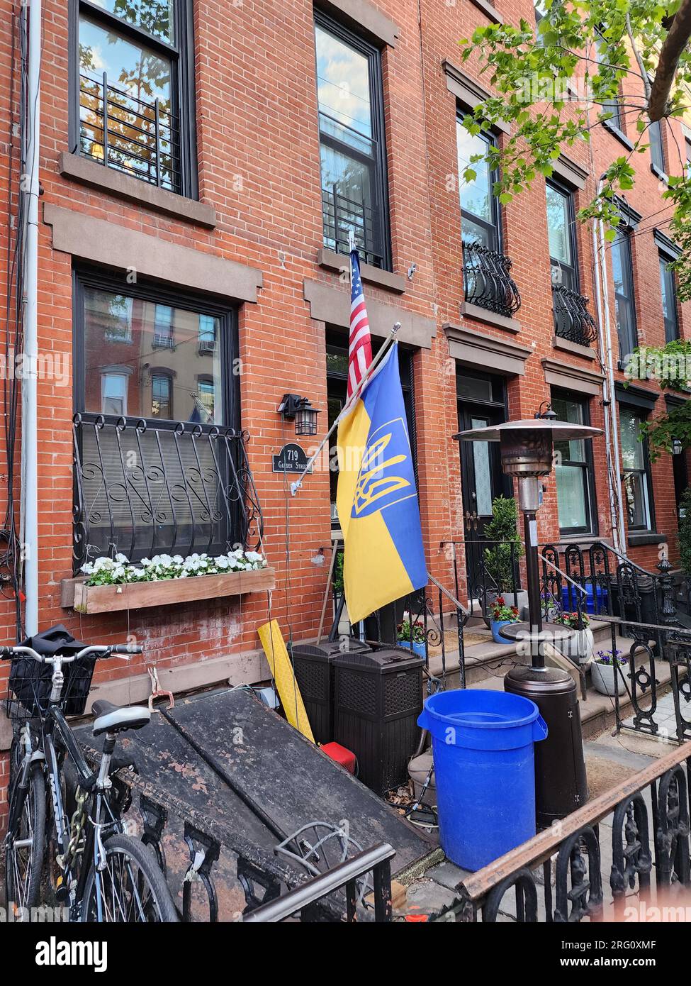 New York City, USA - May 06, 2023: brownstone with american and ukrainian flag on the backyard. Stock Photo