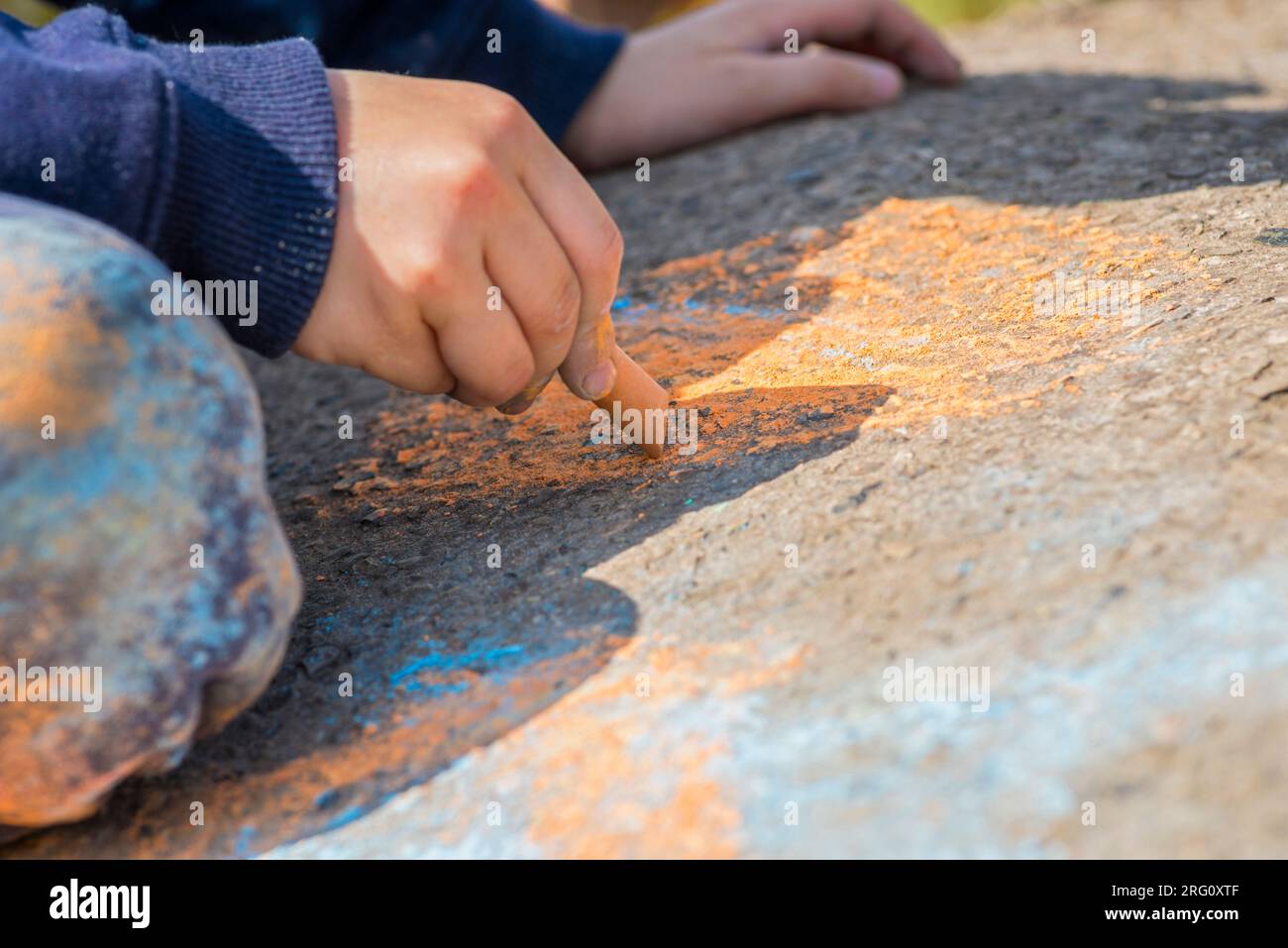 The child drawing a chalk on asphalt Stock Photo - Alamy