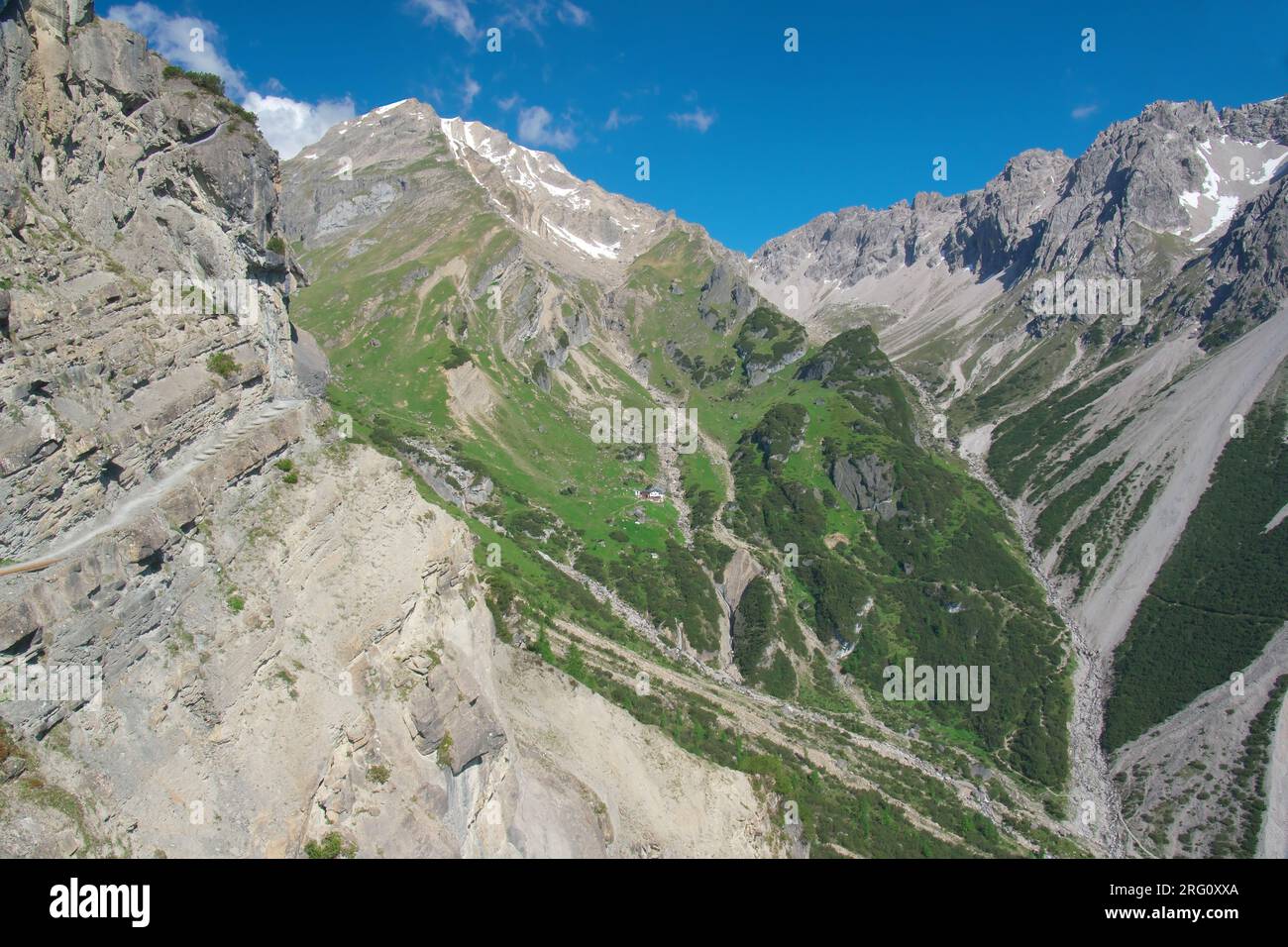 'Drischlsteig' (Drischl mountain-path, on the left) leads from Hoch-Imst Alpjoch to Muttekopfhuette (centre of the image, small) at the bottom of Mutt Stock Photo