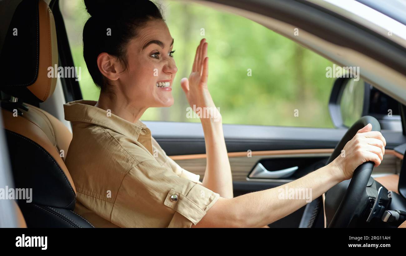 Brunette woman mad at driver clipping car on roadway Stock Photo