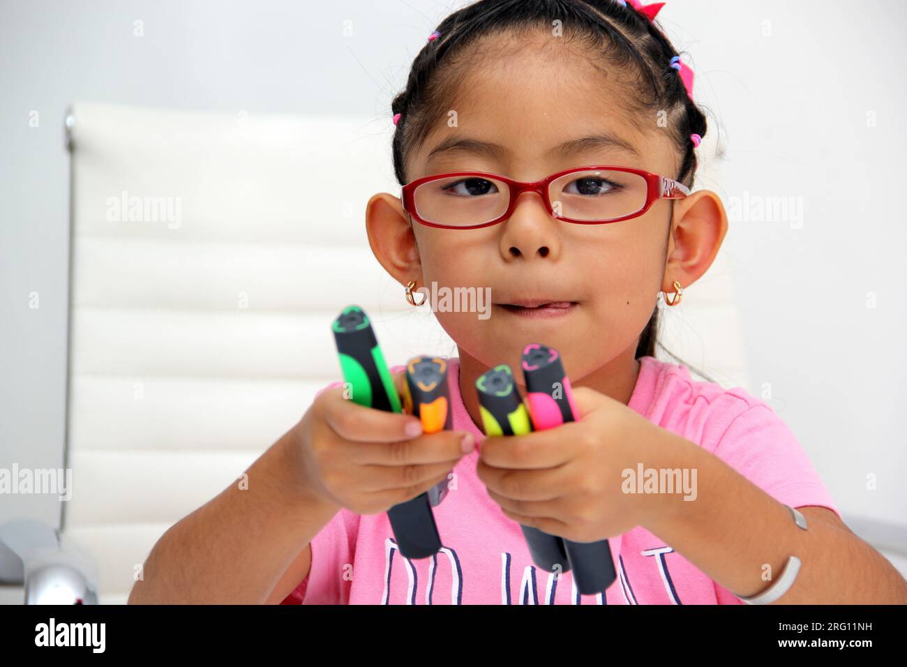 4-year-old brunette Latina girl with autism spectrum disorder ASD like Asperger, Rett and Heller draws at a desk, plays with colors alone antisocial Stock Photo