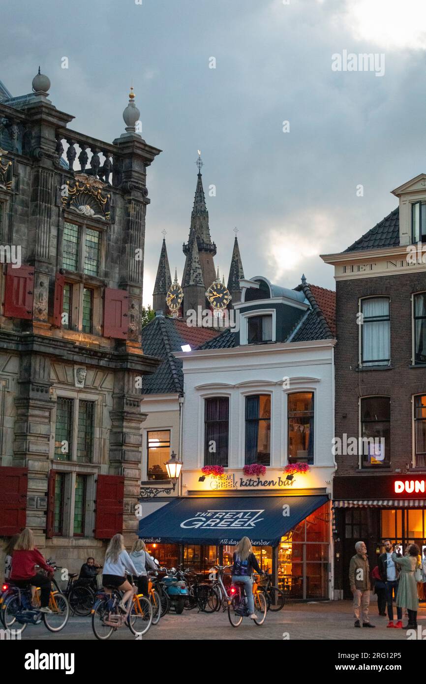 Medieval historical town hall and cafes of Delft during sunset with clouds Stock Photo