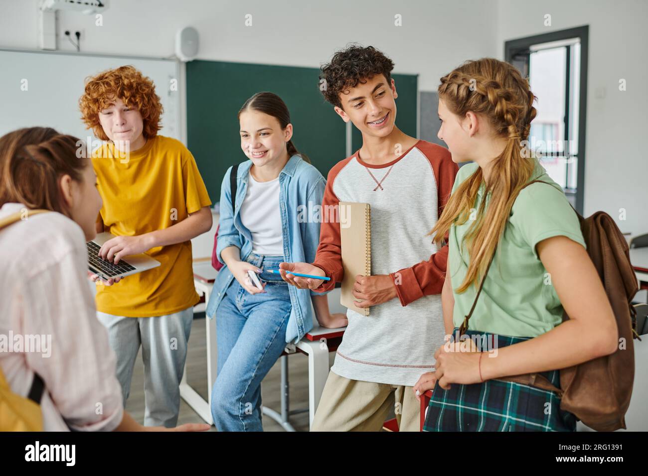 happy teenagers talking in classroom back to school classmates
