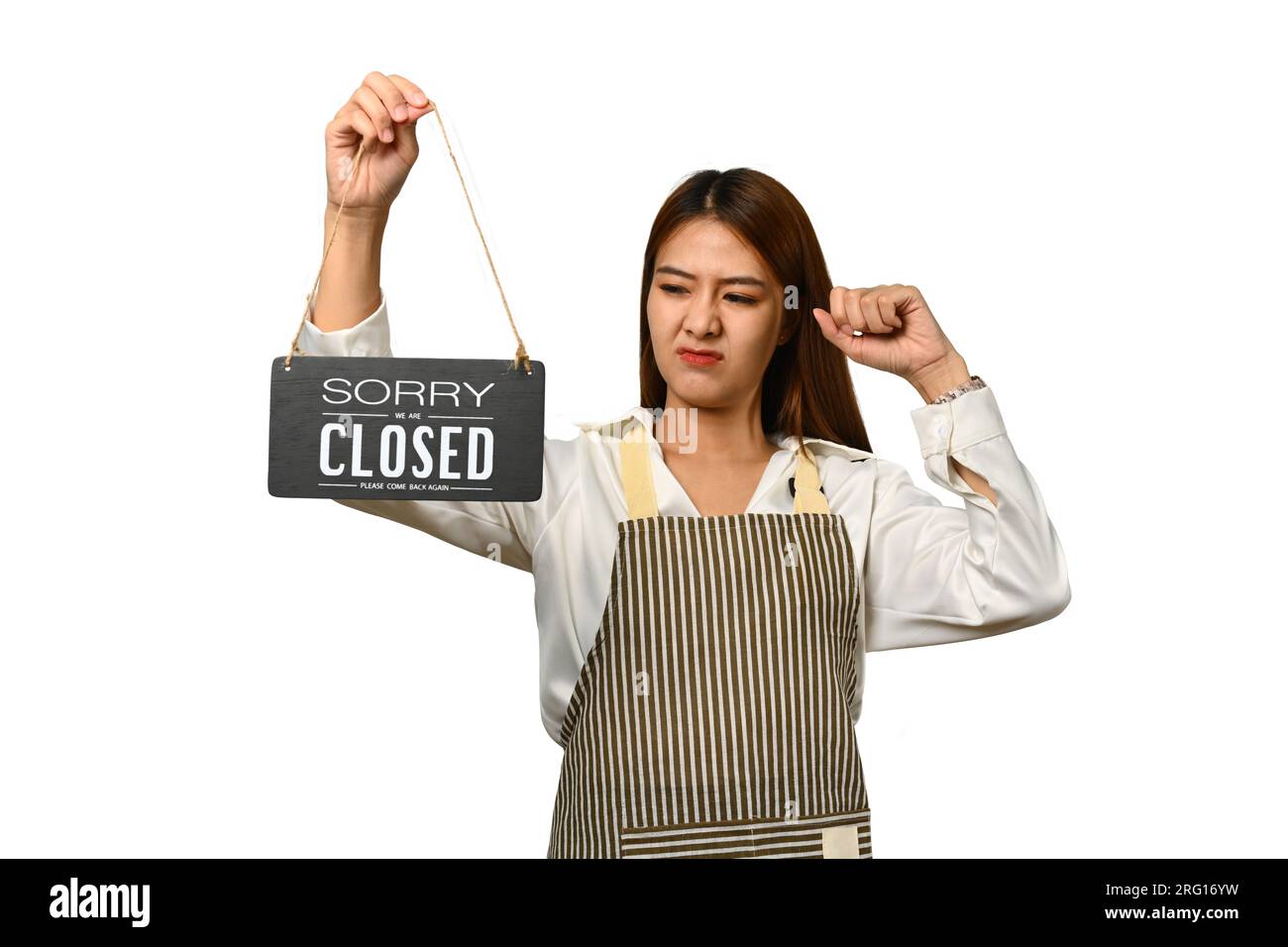 Young woman small business owner in apron holding closed sign isolated on white background Stock Photo