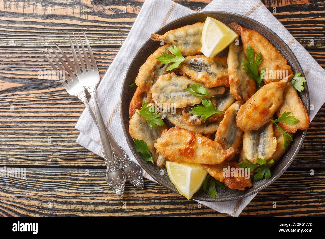 Seafood small sea fish, anchovies sardines deep fried food closeup on the table. Horizontal top view from above Stock Photo