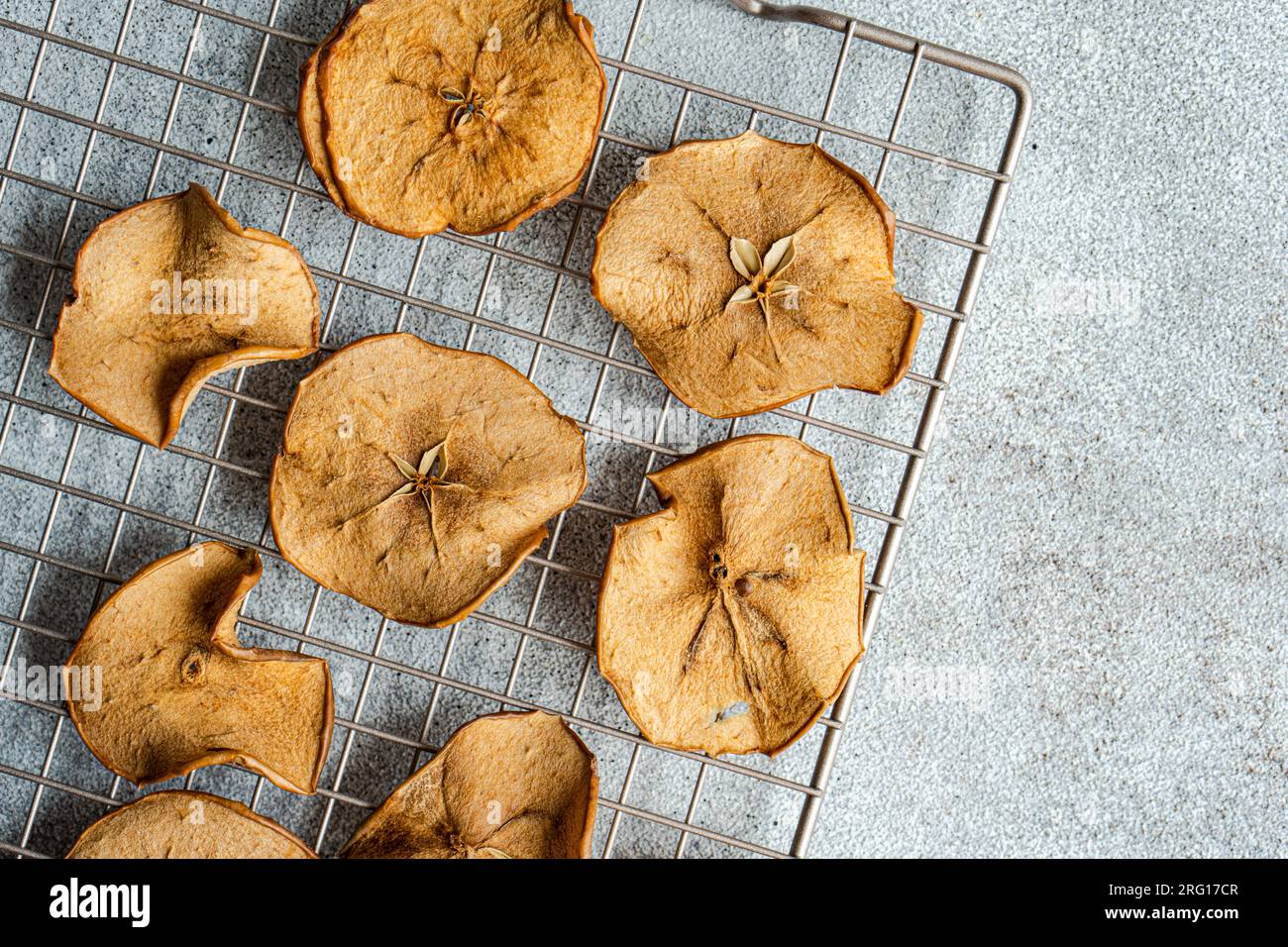 Top view of slices of dried apples on oven tray against blurred gray background Stock Photo