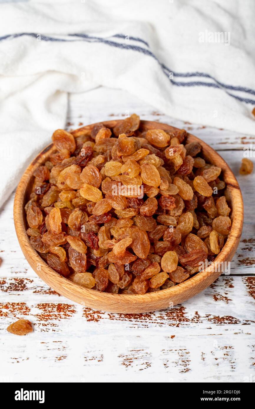 Raisins in wooden bowl. Sun-dried natural raisins on a white wood ...