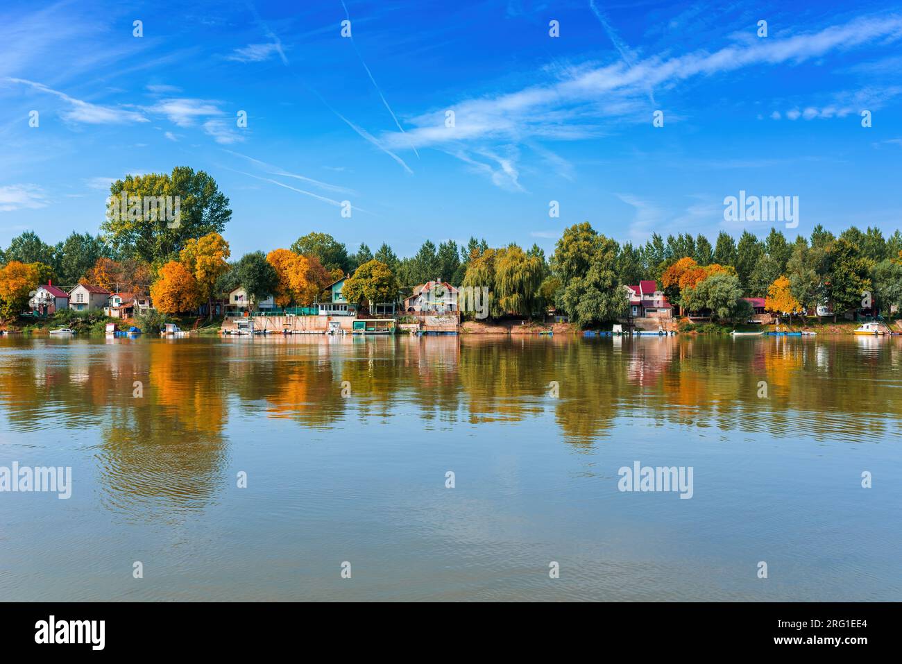 River Tisza and tiny houses at its riverbank in autumn. Beautiful seasonal landscape from Vojvodina, Serbia. Stock Photo