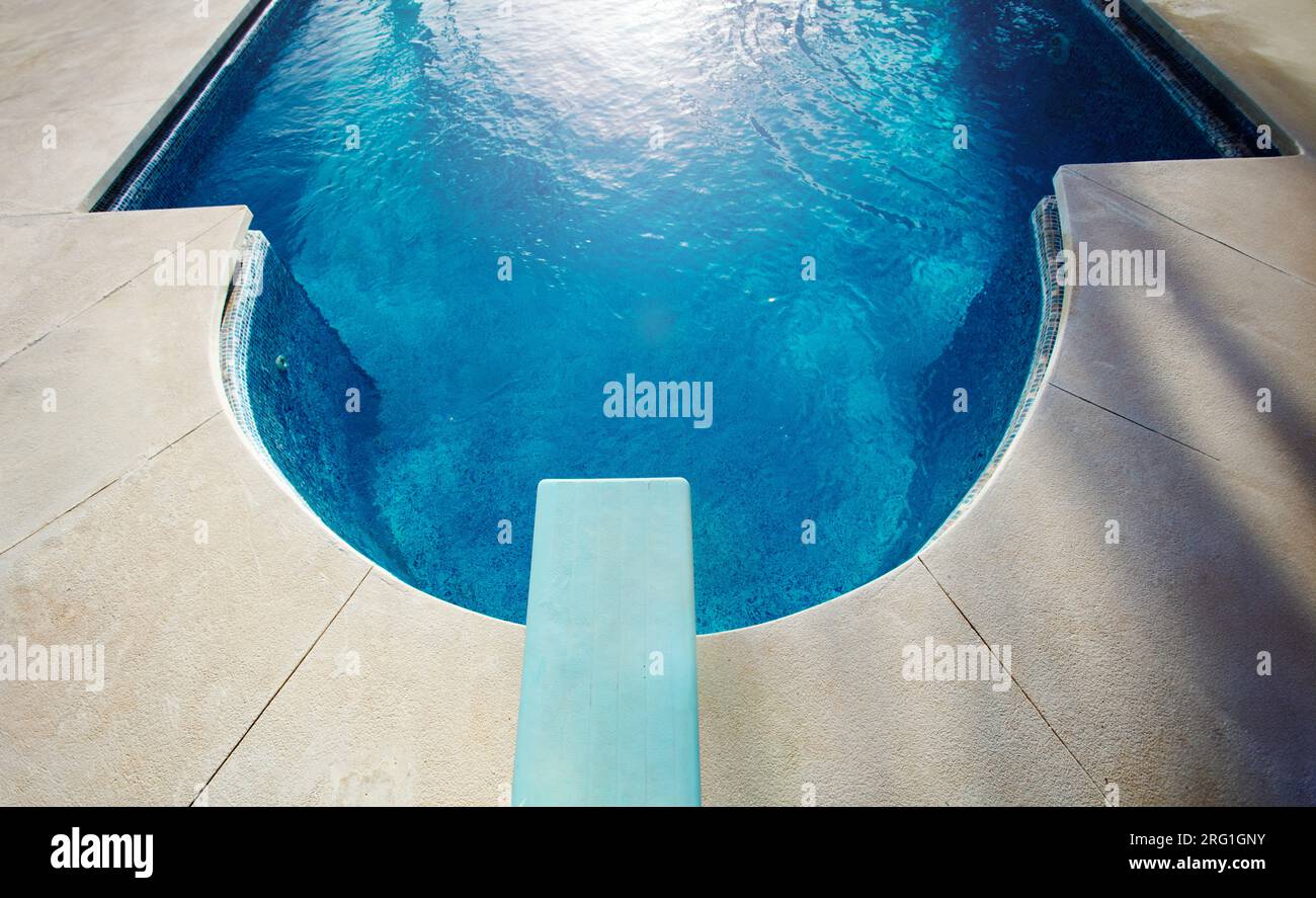 Diving board view from above and blue water of swimming pool Stock