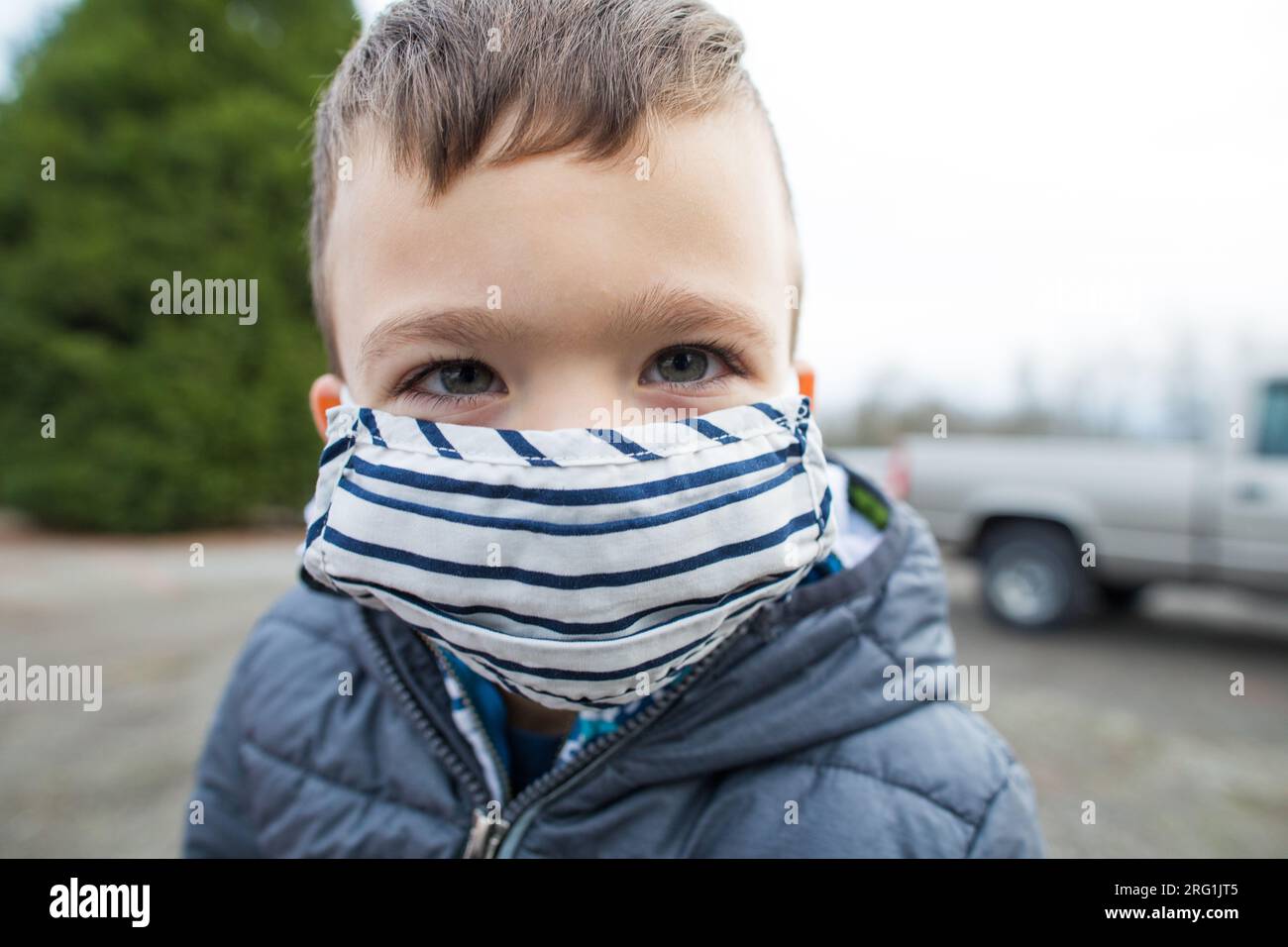 Close up Portrait of young boy wearing mask outdoors Stock Photo - Alamy