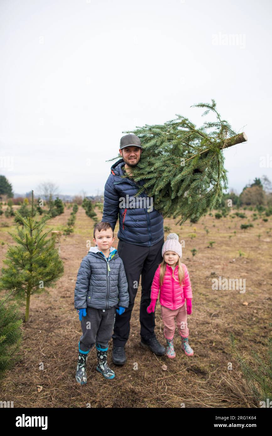 Dad and his two kids pictured with their Christmas Tree Stock Photo - Alamy