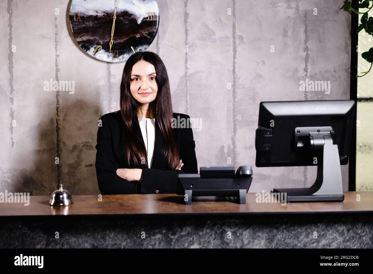 Portrait of receptionist at desk in lobby. Banner design. Friendly concierge at hotel reception behind the counter Stock Photo