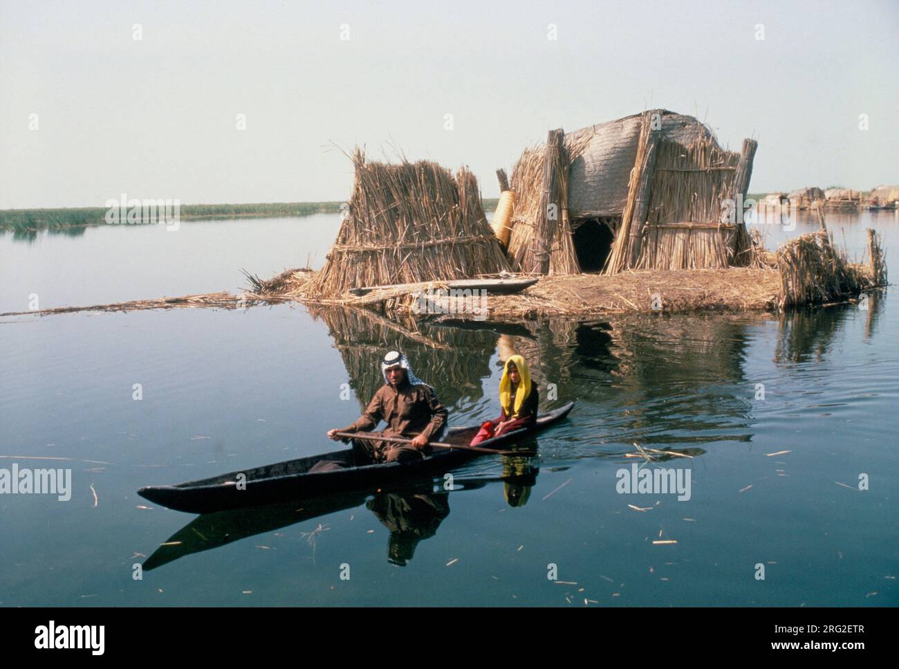 Marsh Arabs Southern Iraq. Marsh Arab man with daughter in boats with traditional reed built island home called a kibasha. Rivers Tigris and Euphrates wetlands, Hammar marshes. Southern Iraq 1980s HOMER SYKES Stock Photo