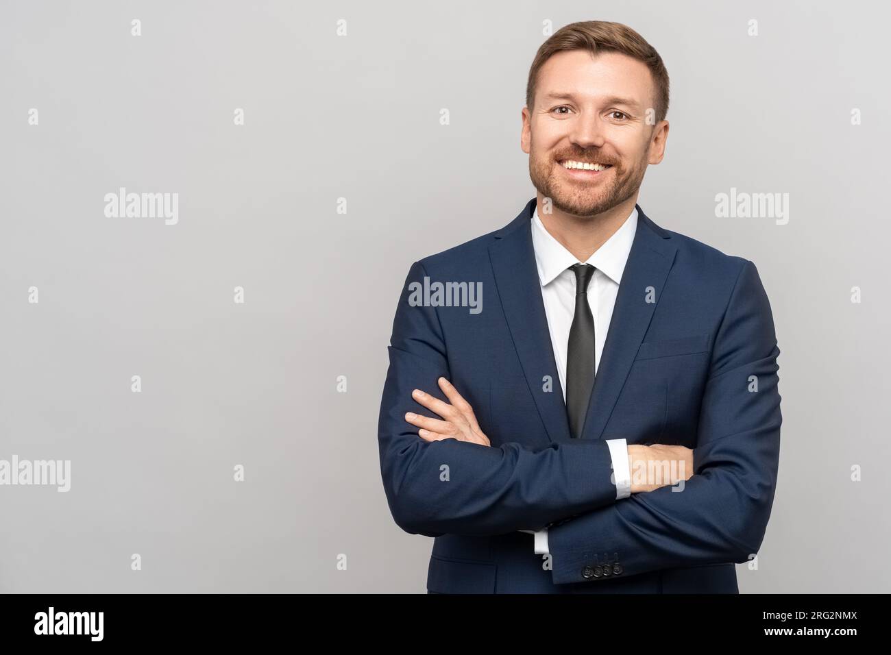 Portrait of happy successful confident businessman in suit with crossed ...