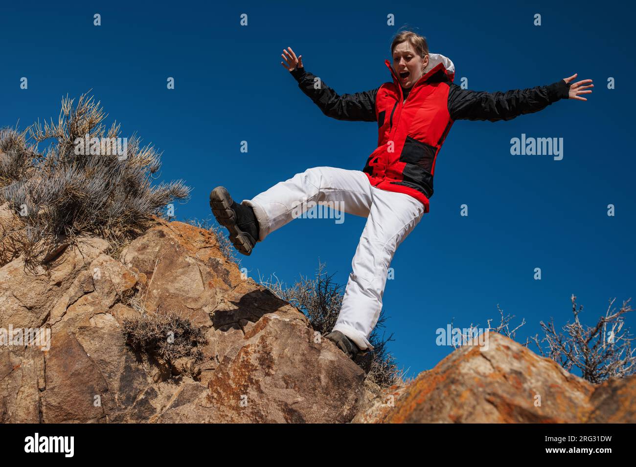 Frightened girl tourist on the edge of a cliff Stock Photo