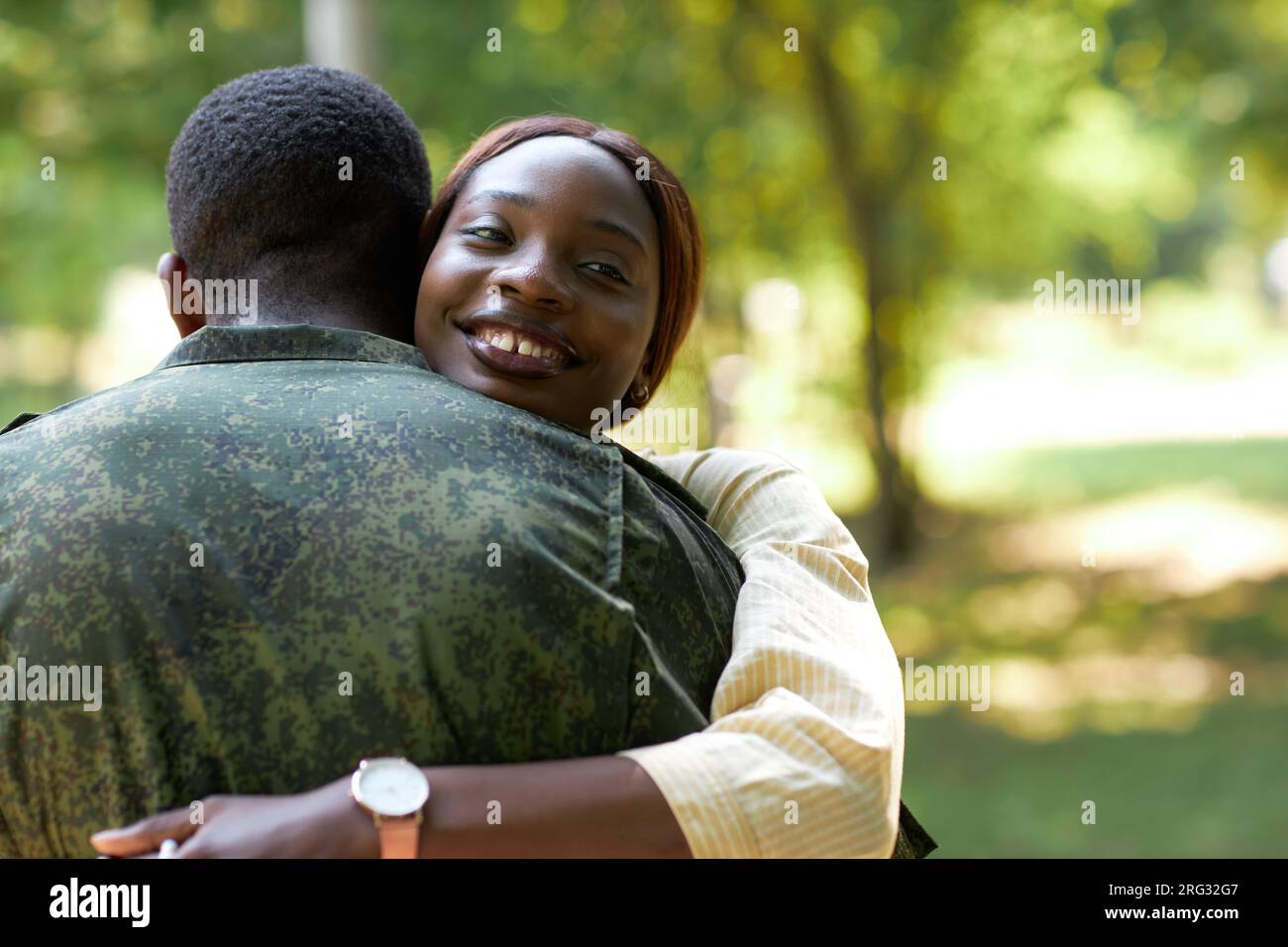 Happy African American woman embracing her military husband while they ...