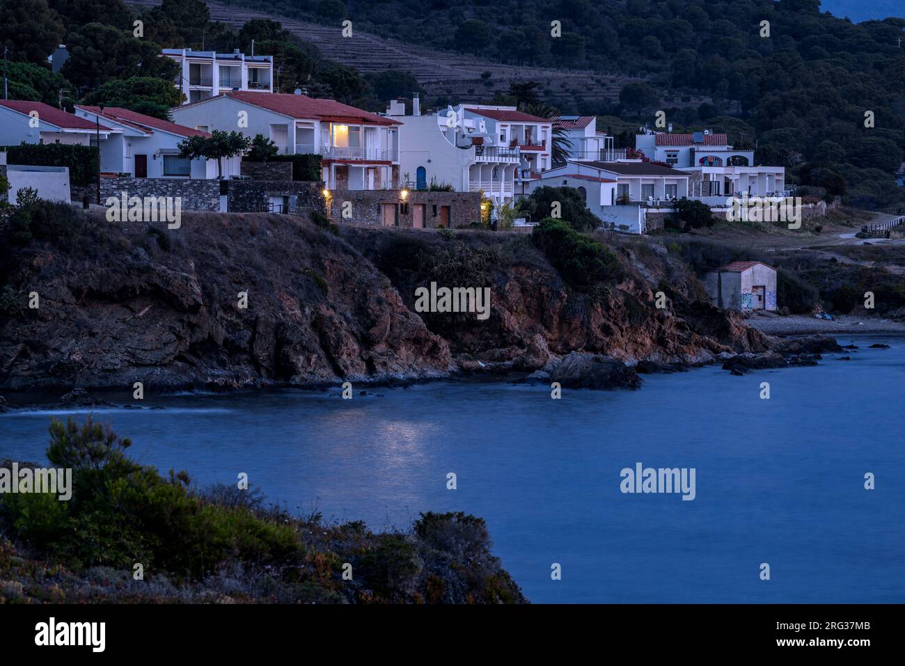 Houses next to the coast of the bay of Port de la Selva at blue hour with the first light of the morning (Alt Empordà, Girona, Catalonia, Spain) Stock Photo