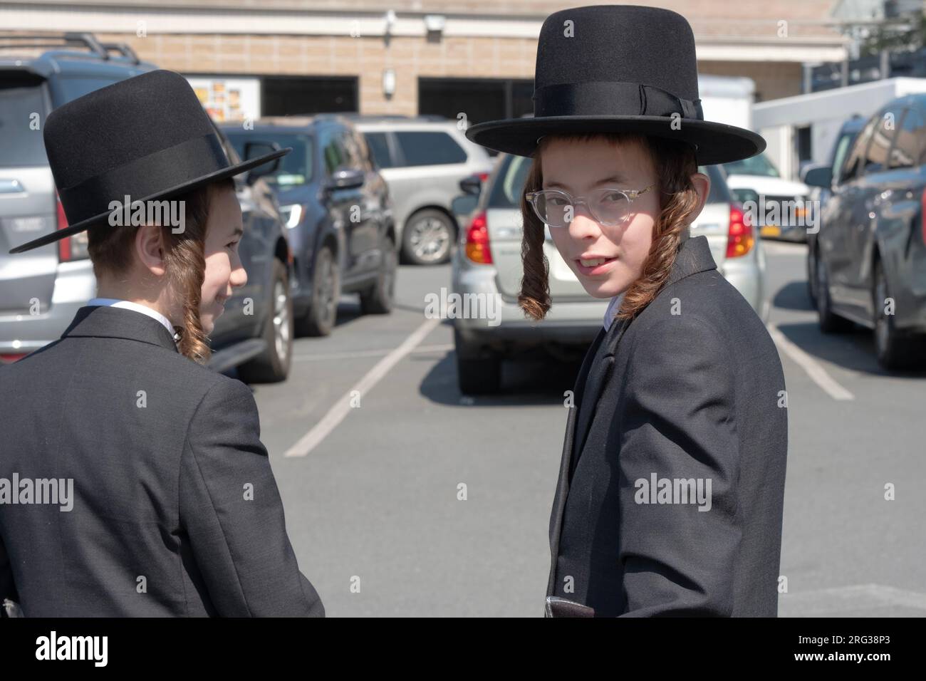 2 Satmar teenagers with long peyus stop for a photo on the way to shopping at the Kiryas Joel Shopping Center in Orange County New York. Stock Photo